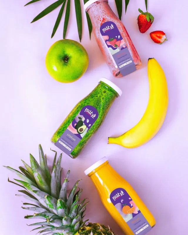 Farghali juice bottles arranged with fresh fruit on a lilac background
