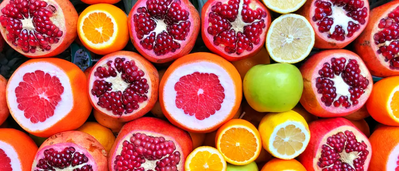 Rows of halved pomegranates, grapefruits, oranges and limes