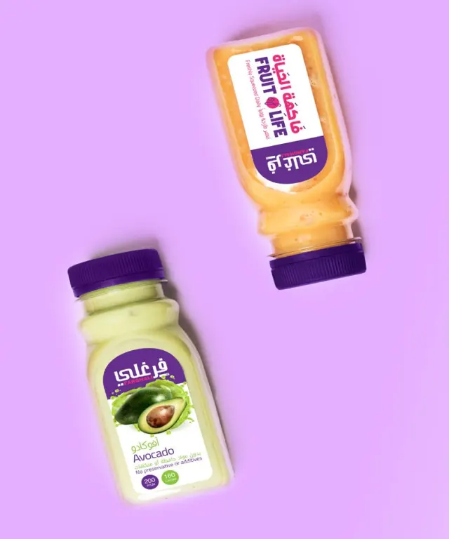 Farghali avocado, pomegranate and Fruit of Life juice bottles on a lilac background